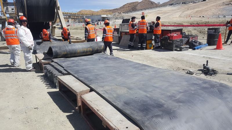 Cuadrilla preparando empalme vulcanizado de banda en mina